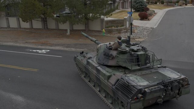 Teenager driving large tank onto neighborhood road