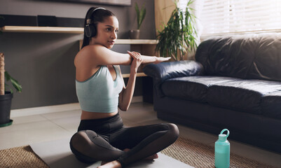 Fitness, stretching and woman on mat with headphones for cardio, exercise or podcast in workout. Female person, thinking and training with music at home for streaming, warm up and self care on floor - obrazy, fototapety, plakaty