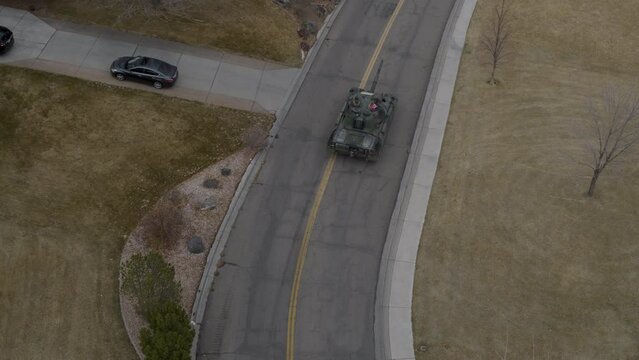 Following old German tank on neighborhood road - high, drone shot