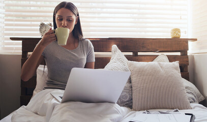 Bedroom, coffee and woman with laptop for remote work, relax and research for online career....