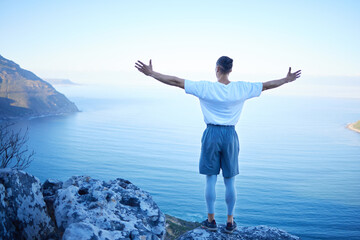Man, hiking and back with freedom, arms and stretching for success with view of mountains, sea and...