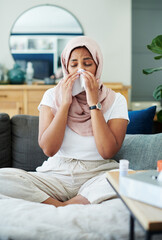 Muslim, woman and sick or sneezing on couch in living room with illness, flu and tired at home....