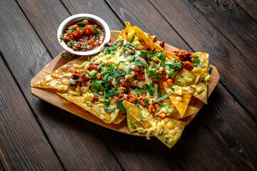 Nachos chips and dipon dark boards background. Menu for a pub