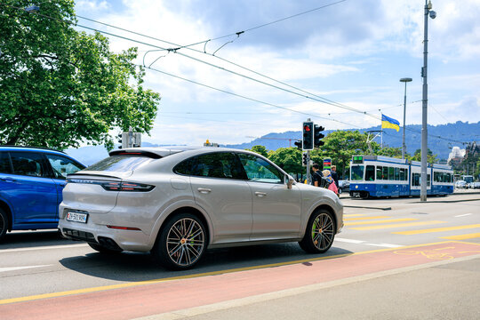 Porsche Cayenne E-Hybrid Coupe stopped at junction for pedestrians in crosswalk in Zurich, this Porsche Cayenne is available in both SUV and Coupe styling