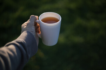 a man holds a mug of coffee, tea and moves