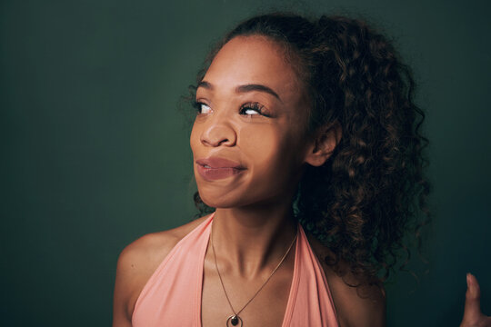 Woman, face and crush on glass or funny in studio with comic expression, humor or press on transparent window. Model, person or squash of lips, nose or uncomfortable with accident on green background