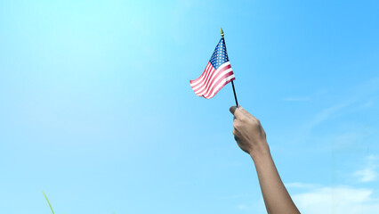 Closeup view of a human hand holding an American flag - obrazy, fototapety, plakaty