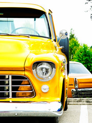 Vintage yellow truck on display at classic vehicle exhibition.