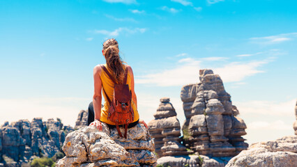 Rear view of tourist woman with bag enjoying landscape rock panorama (torcal)Andalousia in Spain