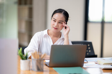 A focused businesswoman in deep concentration, reviewing complex data on her laptop in a bright office space.