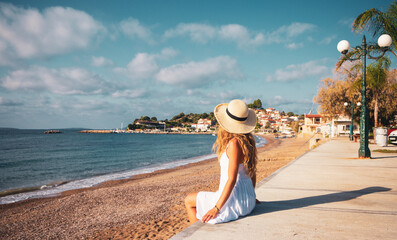 young woman sitting on the beach enjoying beautiful view