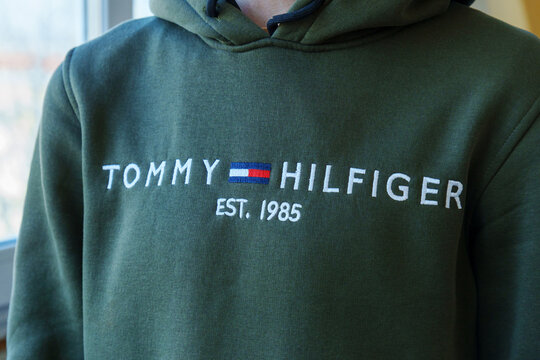 Tyumen, Russia-January 11, 2024: Person is standing while wearing a green Tommy Hilfiger sweatshirt, showcasing the brand iconic logo.