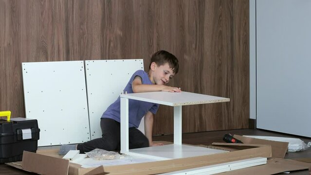 Little Boy assembling furniture. Furniture repair and assembly