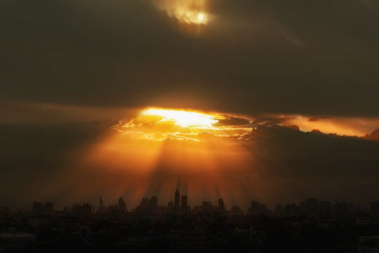 Background of sunlight orange with sky clouds in black silhouette city.