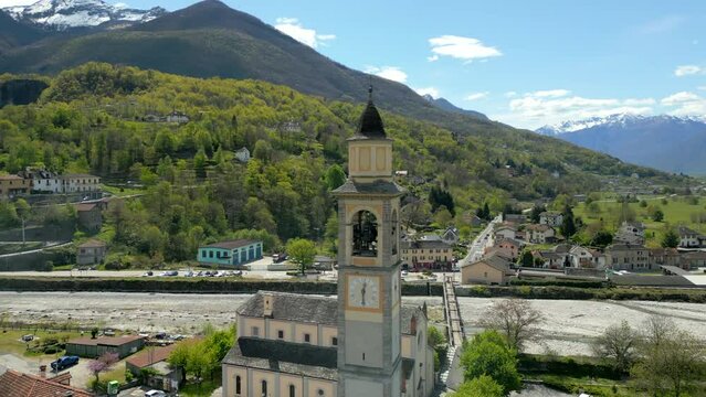 Great view on old swiss village center with beautiful bell tower surrounded by houses located in the foot on mountains, Switzerland, Europe. High quality 4k footage