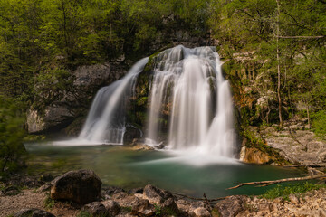 Fototapeta premium Bovec, Slovenia. Visje waterfalls. Nature trail crystal clear, turquoise water. easy trekking, nature experience, wood path. Waterfalls inside a forest, long photographic exposure, power of nature.