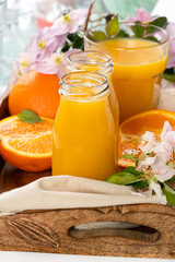 Orange juice in the glass bottles on a tray