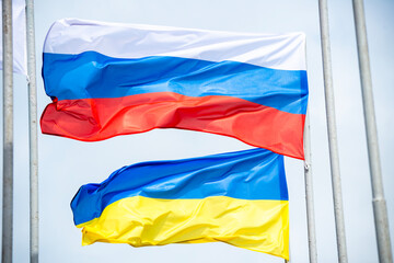 Russian and Ukrainian flags are waving with wind over blue sky. Low angle view. Dispute and conflict concept. Horizontal composition with copy space. - 787926608