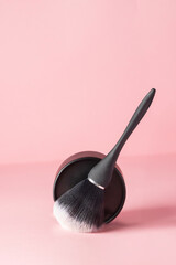 Compact powder box and black brush on pink background, modern make up advertising of cosmetic product - 787927216
