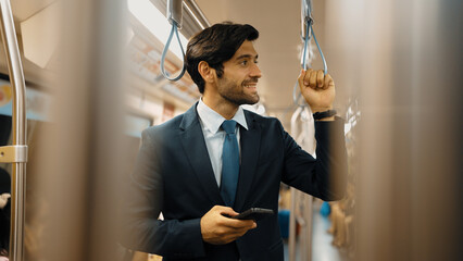 Skilled business man standing in train or subway while holding phone. Professional project manager...