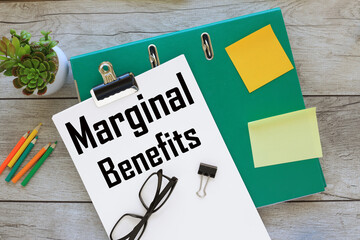 MARGINAL BENEFITS text on white paper on a green folder