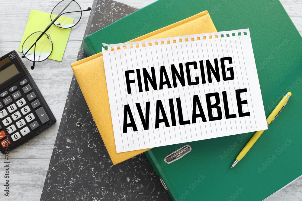 Poster financing available text on a notebook on a green folder