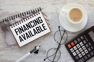Financing Available. calculator and cup of coffee. text on a notepad - obrazy, fototapety, plakaty