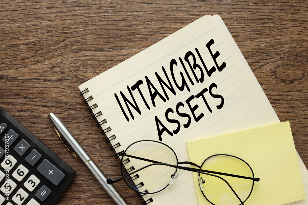 Poster intangible assets glasses lie on a notepad near the calculator. text