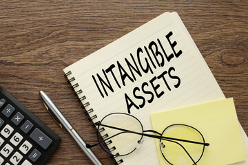 intangible assets glasses lie on a notepad near the calculator. text