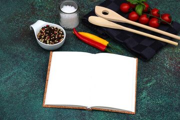 Blank open book with wooden spoons and ingredients for cooking.