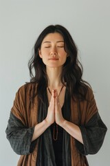 Asian woman gracefully practices the Prayer hands pose, or the prayer mountain pose.