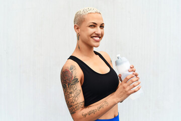 Woman, athlete and drinking water in studio, portrait and hydrate after workout on white background. Female person, nutrition and mineral liquid for recovery after exercise, fitness and mockup space