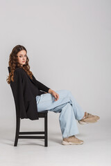 girl model in black shirt and blue trousers jeans posing relaxed in studio - 787956421