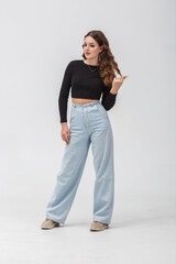 girl model in black shirt and blue trousers jeans posing relaxed in studio - 787956435