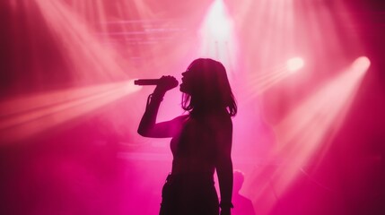 Silhouette of a female singer performing on the Stage, holding the microphone, smoke and illuminated backlit stage lights.