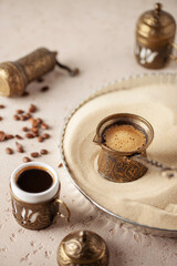 Traditional turkish coffee in cezve prepared on hot sand.