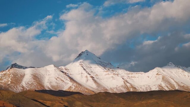 Clouds above the snow covered Chau Chau Kang Nilda mountain during the sunset as seen from Langza village in Spiti Valley, Himachal Pradesh, India. Clouds above the snowy Himalayas during sunset.