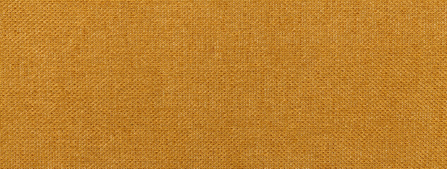 Texture of dark orange color background from textile material with wicker pattern, macro. Vintage ocher fabric
