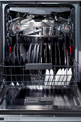 An open dishwasher is filled with clean dishes in kitchen