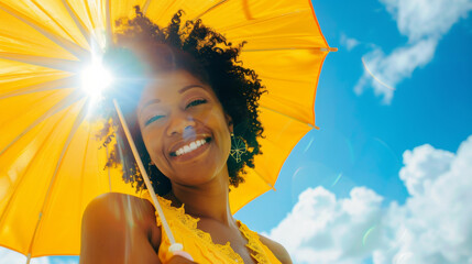 Happy black afro american woman with sunny blue sky holding a yellow umbrella or sunshade to protect her skin from sun light with return of warm days