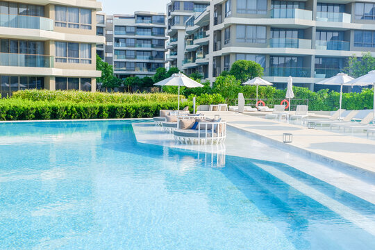 Empty swimming pool with sunbed and white umbrella in resort hotel for vacation leisure and white sand,resort neary sea and beach in summer..