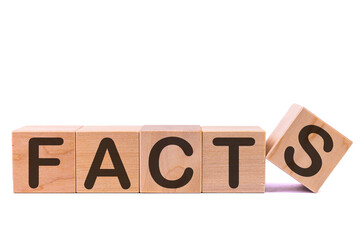 Word FACTS is made of wooden building blocks lying on the table and on a light background. Concept.