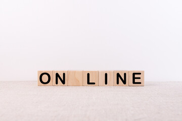 ON LINE word concept written on wooden cubes blocks lying on a light table and light background