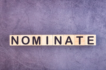 NOMINATE word made with wood building blocks.