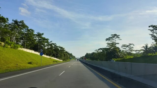 Semarang, Indonesia - April 17 2024 : Morning atmosphere on the Indonesian Semarang toll road from inside a moving car. Semarang, and you can see views of hills and rice fields. Central Java, Indonesi