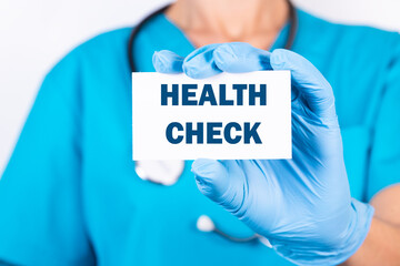 Doctor holding a card with text Health Check, medical concept.