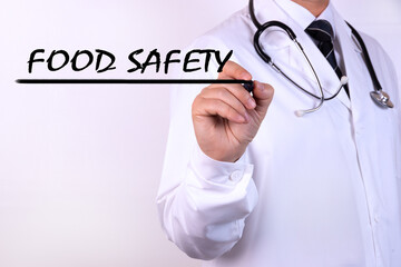 Doctor writing word Food Safety with marker Medical concept