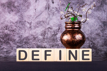 Word DEFINE made with wood building blocks on a gray back ground.