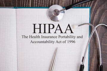 Notebook page with text HIPAA The Health Insurance Portability and Accountability Act of 1996, on a table with a stethoscope and pen, medical concept.