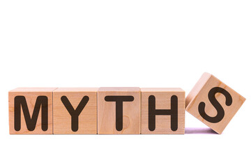 Word MYTHS is made of wooden building blocks lying on the table and on a light background. Concept.